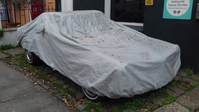 Can you guess what car’s under the tarpaulin?